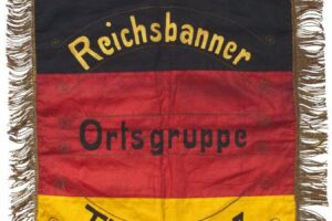 Harz_des_"Reichsbanner_Schwarz-Rot-Gold"._Fahnentuch_in_den_Farben_Schwarz,_Rot_und_Gold_mit_Kurbelstickerei_"Reichsbanner_Ortsgruppe_Thale_-_Harz",_schauseitig_der_Reichsadler._Eingefasst_mit_goldenen_Fransen._48_x_57_cm._Selten.