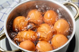 Topf mit neun Hühnereiern in kochendem Wasser