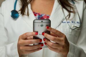 Female doctor with smartphone in her hands